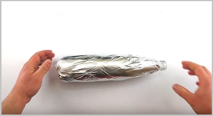 Wrapping the glass bottle with silver paper