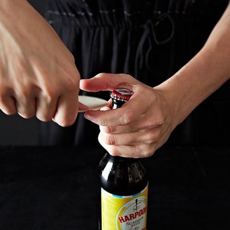 Use a spoon to lift the edges of the bottle cap.