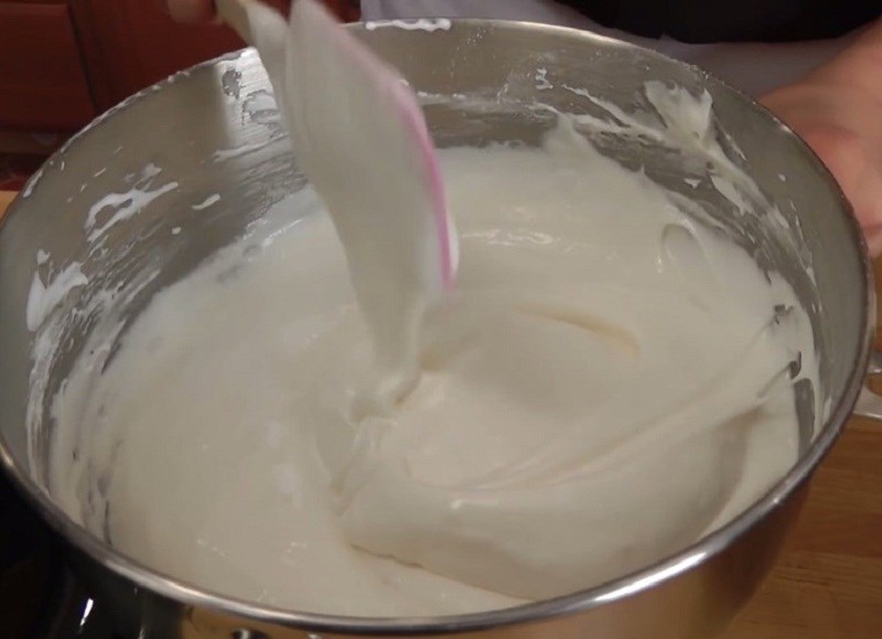 Từ từ cho bột vào lòng trắng trứng đánh bông và trộn cho đến khi hết bột cho đến khi được hỗn hợp mịn