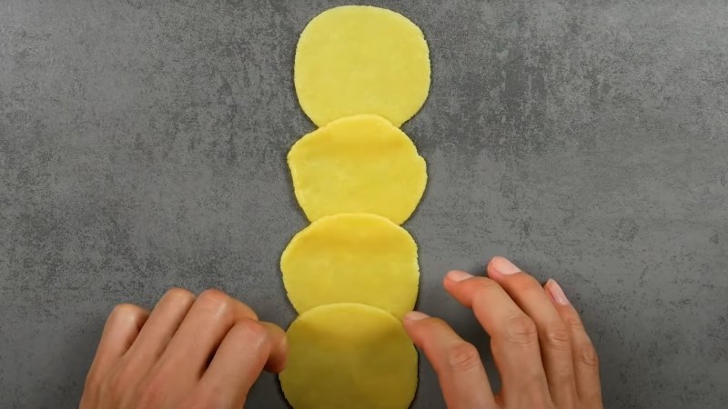 C&aacute;n mỏng v&agrave; xếp bột l&ecirc;n nhau rồi cuộn tr&ograve;n