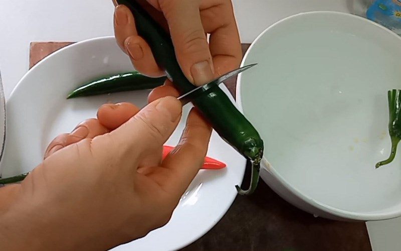 Cắt ớt l&agrave;m đ&ocirc;i, giữ lại phần đầu c&oacute; cuống để l&agrave;m hoa 
