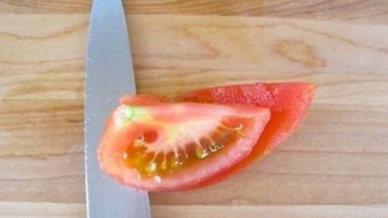 Dùng dao miết vào giữa phần vỏ và thịt quả cà chua