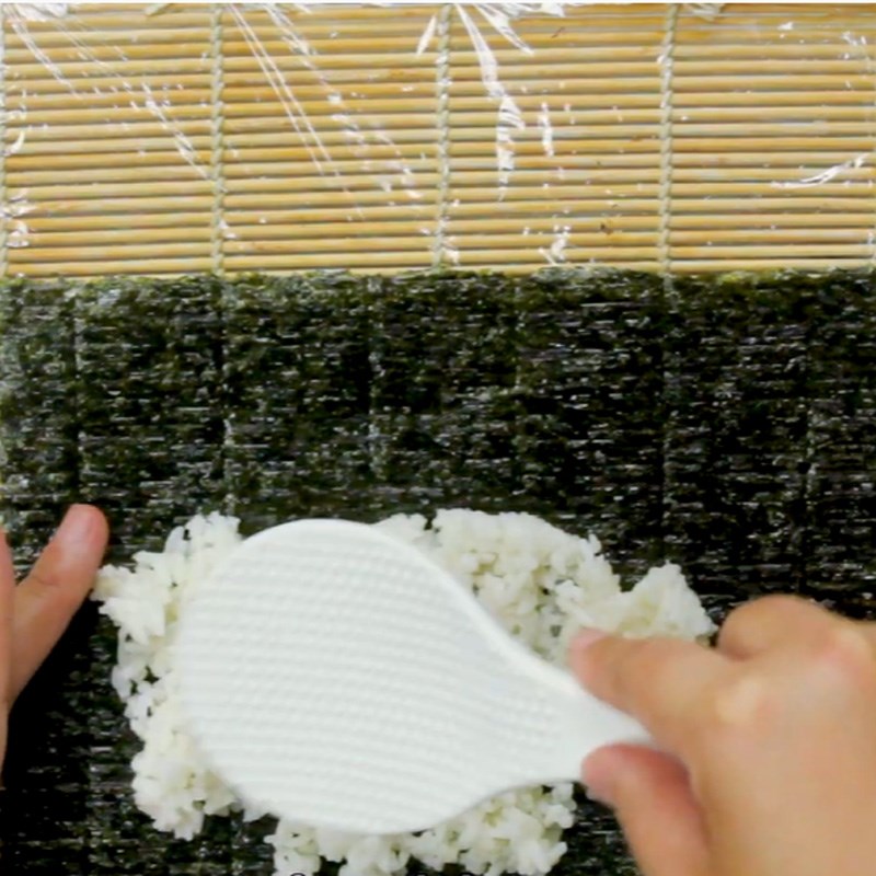 Bước 3 Cho cơm lên lá rong biển Sushi thanh cua