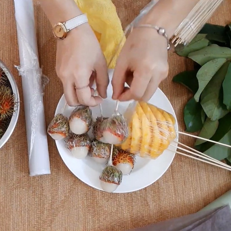 Bước 2  Quấn màng bọc và ghim que xiên Bó hoa từ chôm chôm, thơm 