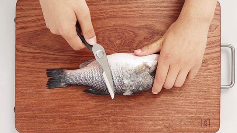 Cạo vảy c&aacute; bằng k&eacute;o