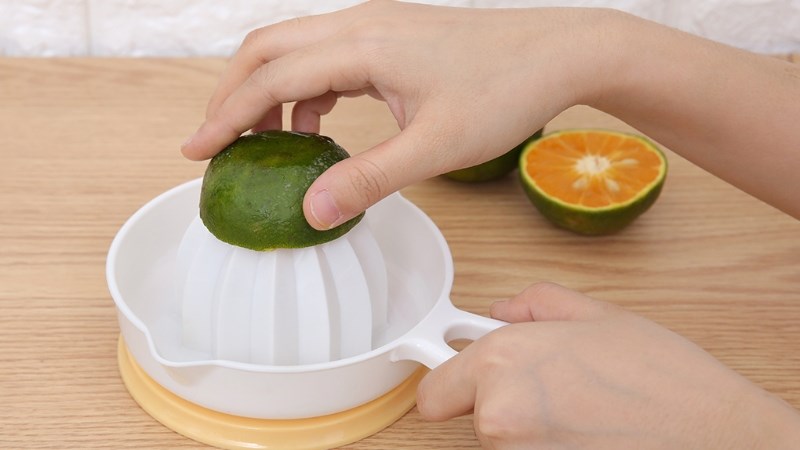 Dùng dụng cụ vắt nước cam