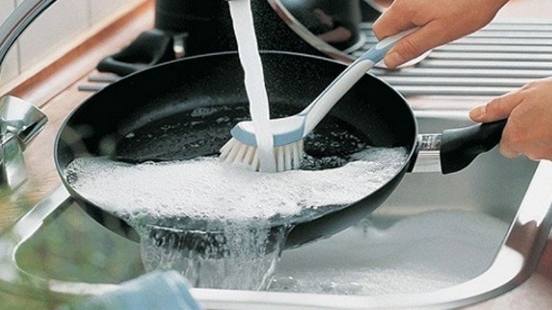 Rửa chảo bằng cọ b&uacute;i sắt, b&agrave;n chải cứng