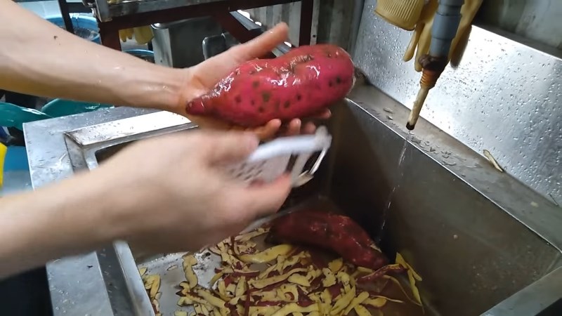 Gọt khoai dưới vòi nước