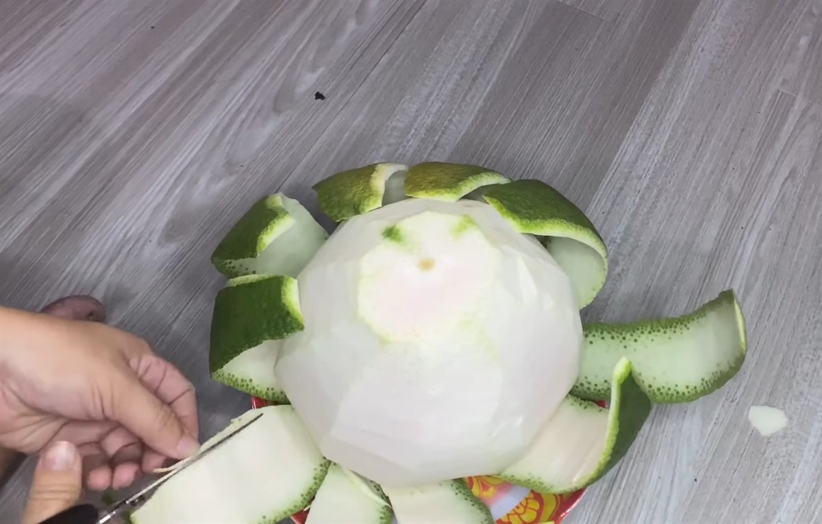 Gọt phần vỏ xanh của quả bưởi để làm đế hoa sen