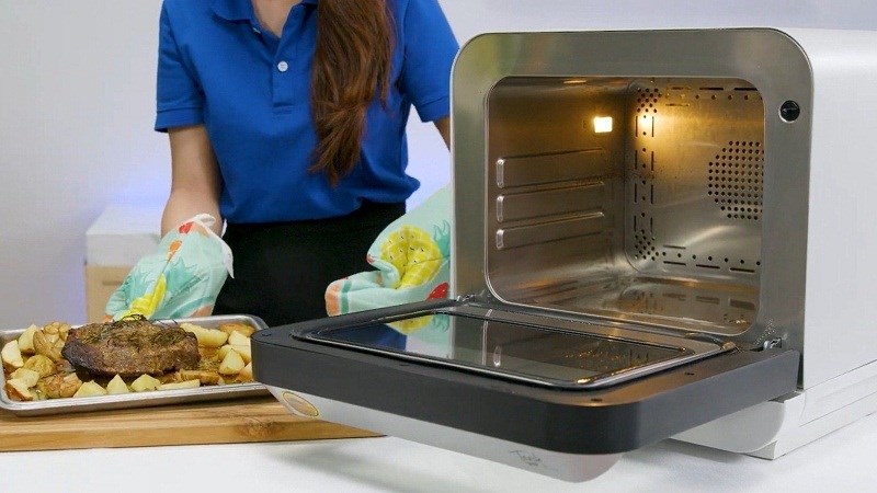 Đeo găng tay lấy khay thịt ra khỏi l&ograve;