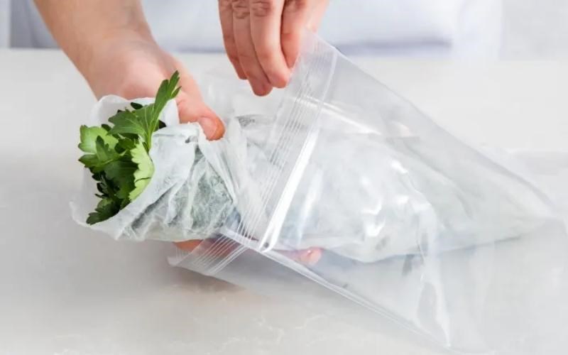 Cuộn giấy lại rồi cho cuộn rau vào túi zip, đóng chặt rồi cho vào tủ lạnh
