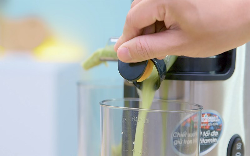 Đổ nước &eacute;p ổi, thơm v&agrave; cần t&acirc;y ra ly