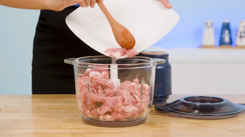 Cho thịt v&agrave;o m&aacute;y xay thịt Bear QSJ-D03P3