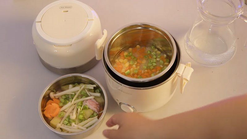 Cho c&aacute;c nguy&ecirc;n liệu v&agrave;o khay hấp v&agrave; ngăn nấu
