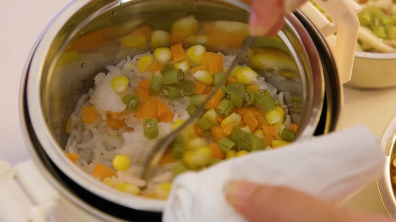 Sau khi hết thời gian nấu, r&uacute;t điện hộp cơm, mở nắp v&agrave; xới thức ăn