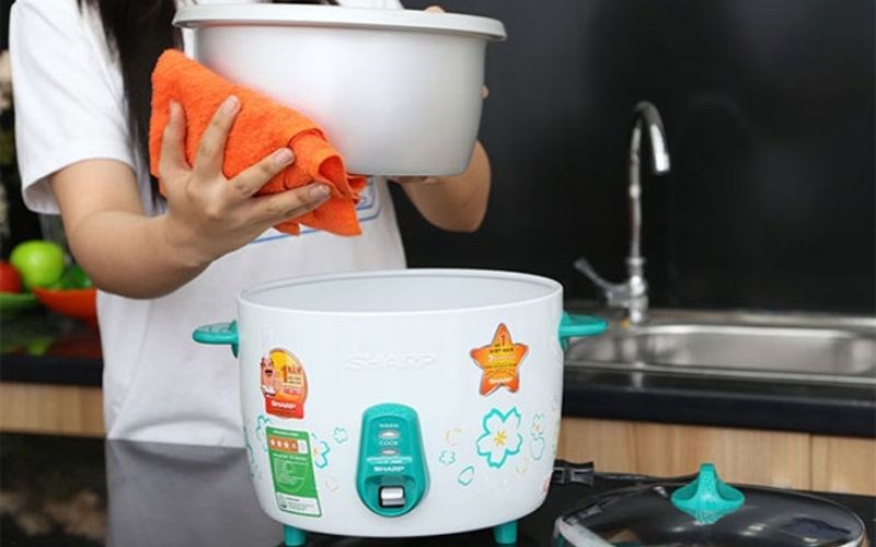 Lau kh&ocirc; mặt ngo&agrave;i của nồi con trước khi đặt v&agrave;o l&ograve;ng nồi