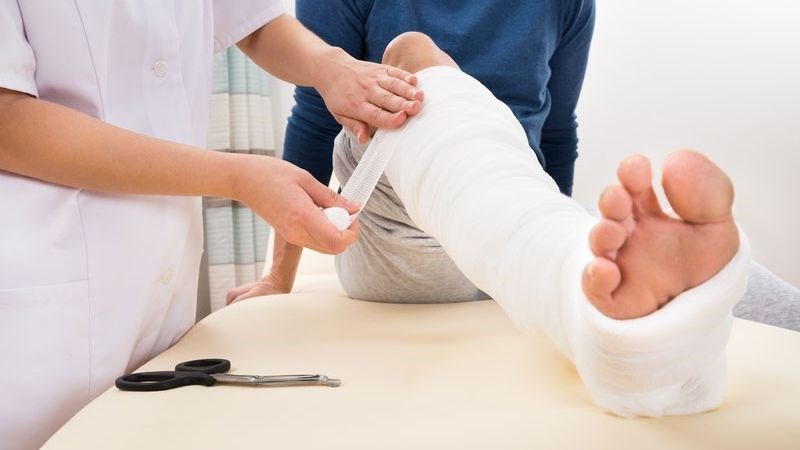 Băng bó và bất động tốt chân bị thương để tránh gãy xương 