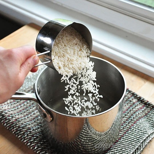 3. Nước sôi, cho gạo, muối, bơ hoặc dầu vào nồi đảo nhẹ nhàng.