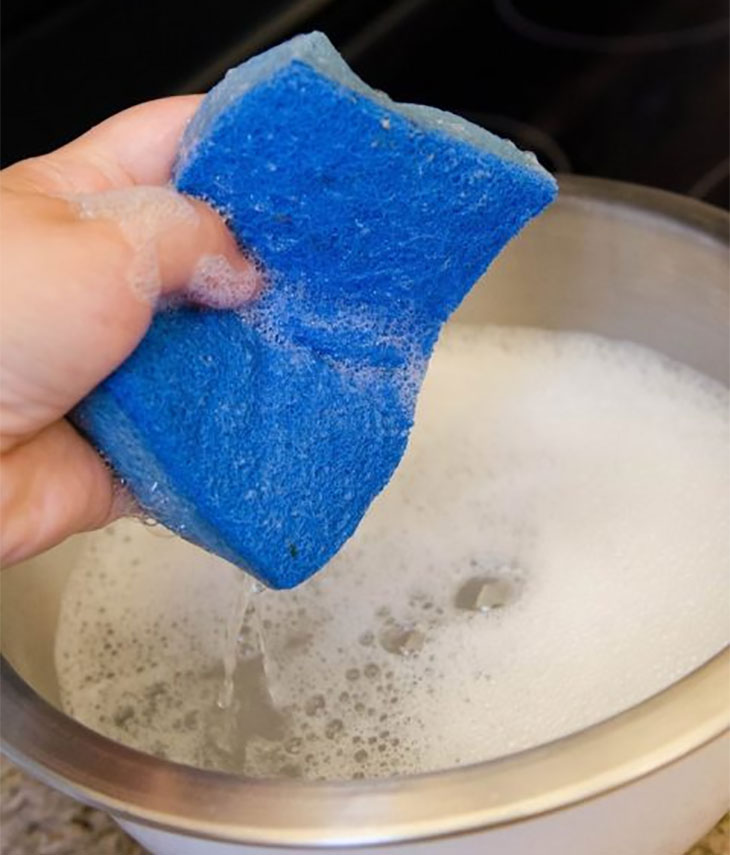 Bạn dùng khăn bông thấm ướt với nước rửa chén đã pha để làm mềm các vết bẩn