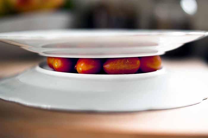 Clamp cherry tomatoes with two forks and cut across