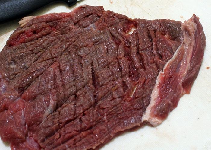 Bắt đầu bạn dùng dao dần cho miếng thịt bò thêm mỏng thêm mềm.