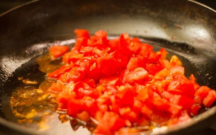 Cho tiếp cà chua cắt nhỏ vào chảo xào, xào trong 5 phút, nhớ đừng để cà chua chín quá.