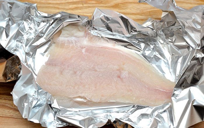 Đặt miếng cá lên giấy bạc theo đường chéo, làm như vậy thì khi gấp các cạnh của giấy bạc, nước sốt, gia vị, cá không bị rớt ra ngoài khi nướng.