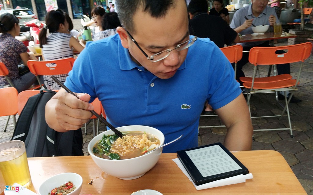 Tay gắp thức ăn, mắt nhìn công nghệ