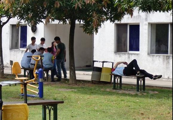 Các công nhân trong nhà máy ở Quảng Châu ngồi chơi ngoài sân, kiên quyết không vào làm việc (ảnh: Nikkei)