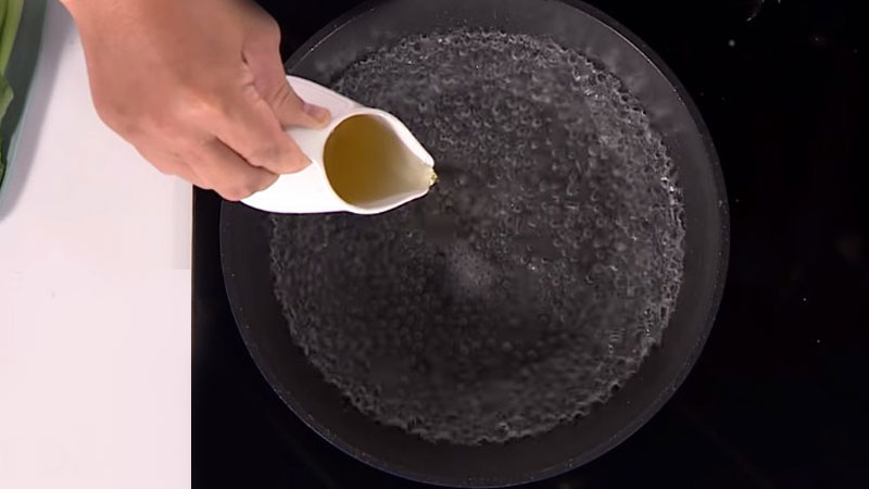 Cho nước và một ít muối vào trong nồi, khi nước sôi lên thì cho dầu ăn vào.