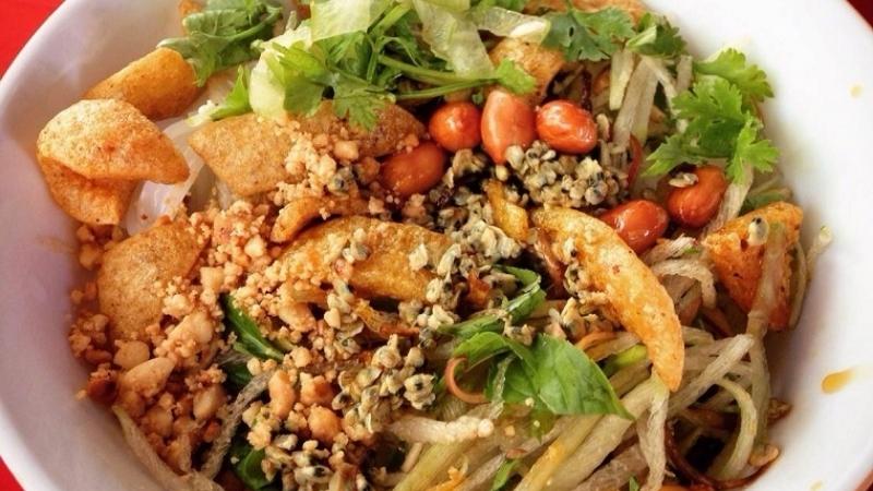 A bowl of rice with clams and vegetables.