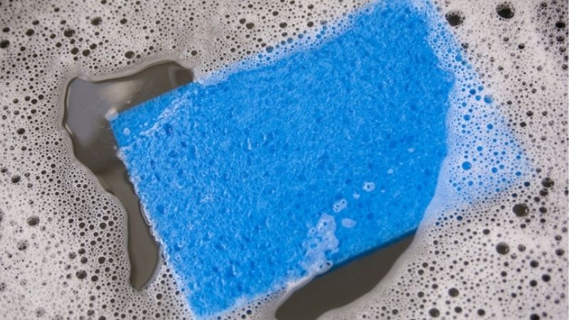 Sử dụng nước tẩy quần áo để làm sạch miếng rửa chén
