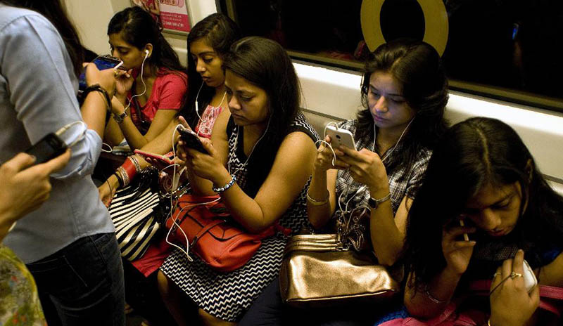 Phụ nữ sử dụng smartphone trên tàu điện