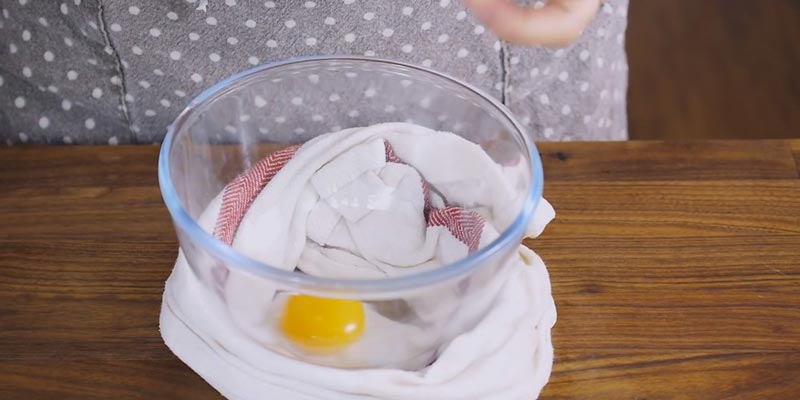 Dùng 1 chiếc khăn sạch bao quanh bát, cho lòng đỏ trứng gà vào, thêm chút muối rồi đánh đều.