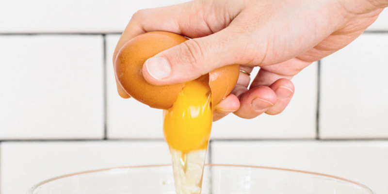 Đầu tiên bạn cầm quả trứng lên, giữ nó bằng tất cả các ngón tay. Ngón tay cái để trên một đầu của quả trứng. Trong khi đó, ngón tay thứ 2 và 3 gây sức ép ở mặt bên kia của trứng.