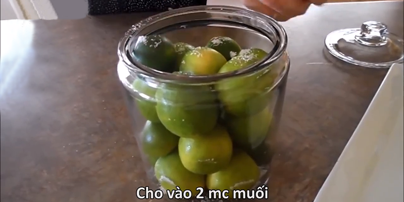 Dùng khoảng 2 muỗng muối bọt rưới đều lên chanh. Sau đó đậy nắp lại