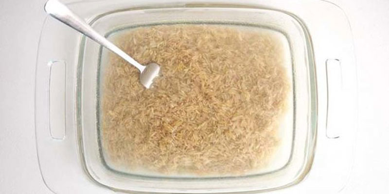 Cho 160 ml nước lọc hoặc nước hầm xương vào hộp thủy tinh đã vo gạo sẵn, tiếp đó đặt vào lò nướng Cho 160 ml nước lọc hoặc nước hầm xương vào hộp thủy tinh đã vo gạo sẵn, tiếp đó đặt vào lò nướng