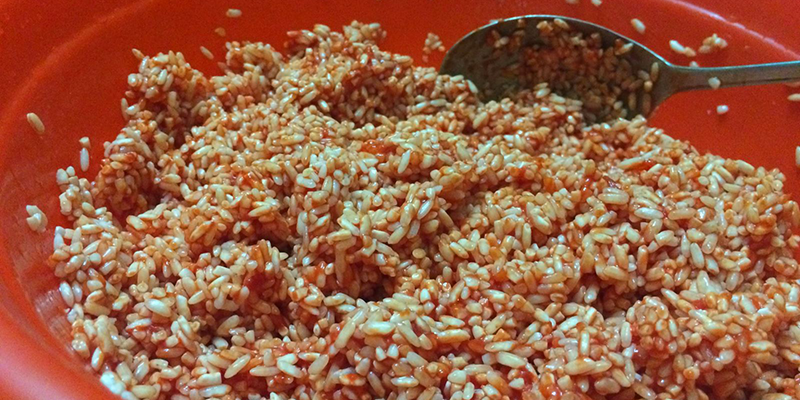 Dùng 1 thao lớn trộn đều phần gạo nếp đã được phơi ráo nước + thịt gấc + ½ nước cốt dừa + một chút xíu muối.