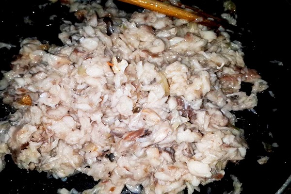 Phi thơm hành khô rồi cho hỗn hợp nghệ, cà rốt, nấm rơm vào đảo qua sau đó cho phần thịt cá lọc được vào xào chung, nêm một chút hạt nêm cho vừa ăn.
