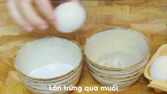 Sau đó lăn trứng qua muối, phải đảm bảo muối bám hết trên vỏ trứng.
