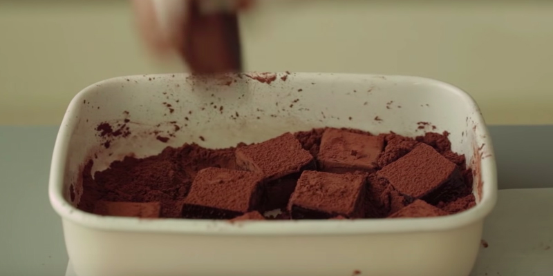 Lăn từng viên nama chocolate qua bột cacao rồi thưởng thức hoặc cho vào hộp để mang tặng gấu.
