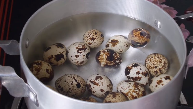 Cho nước và trứng cút vào trong nồi, đặt lên bếp, đậy nắp lại rồi luộc trong 5 phút để trứng chín.