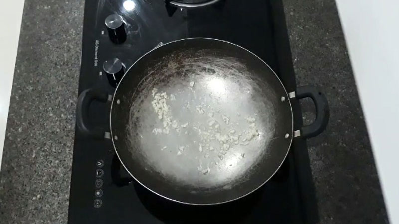 Bắc một cái chảo lên bếp với một ít dầu ăn, khi dầu nóng lên thì cho tỏi vào phi lên cho vàng thơm.