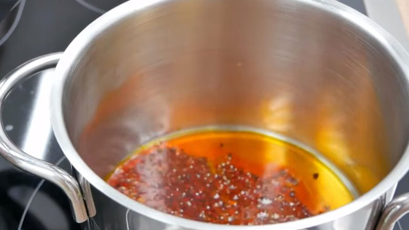 Cho một ít dầu ăn vào nồi, sau đó cho hạt màu điều vào, để hạt màu điều ra hết màu thì tắt bếp.
