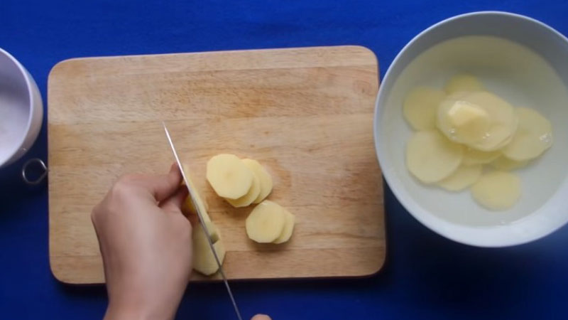 Khoai tây gọt vỏ, rửa sạch, sau đó cắt khoai tây thành từng lát mỏng khoảng 0.5cm