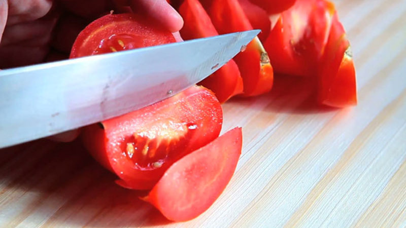 Cà chua sau khi đã được rửa sạch, thì dùng dao cắt thành từng múi cau.