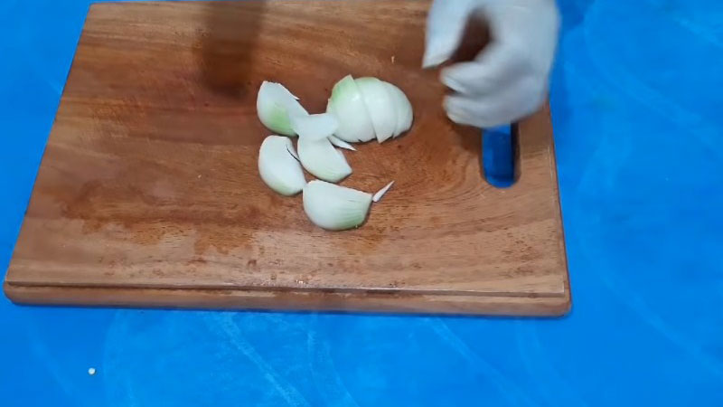 Hành tây lột vỏ, rửa sạch, cắt làm đôi rồi cắt múi cau.