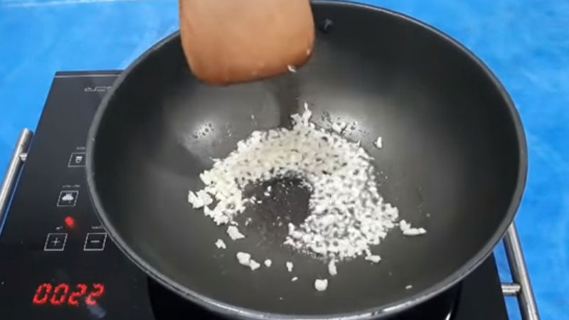 Cho dầu ăn và tỏi vào chảo, đặt lên bếp rồi tiến hành phi cho tỏi vàng thơm.