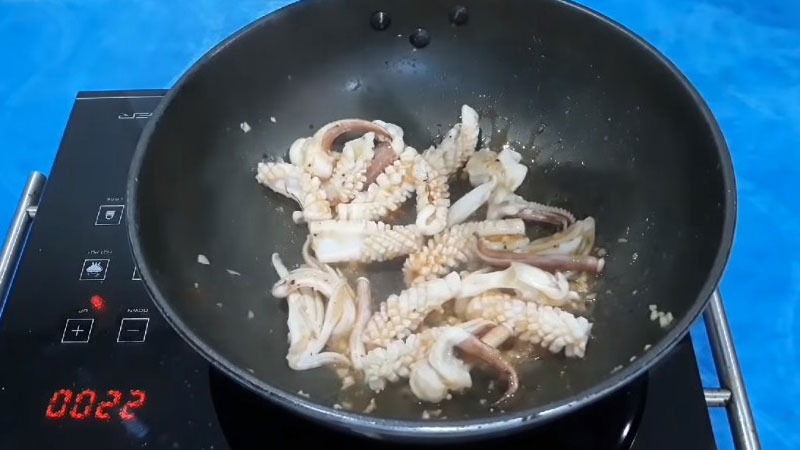 Sau đó cho mực vào xào ở lửa lớn trong 1 phút, rồi hạ nhỏ lửa lại, nêm nếm mực với gia vị cho vừa ăn.