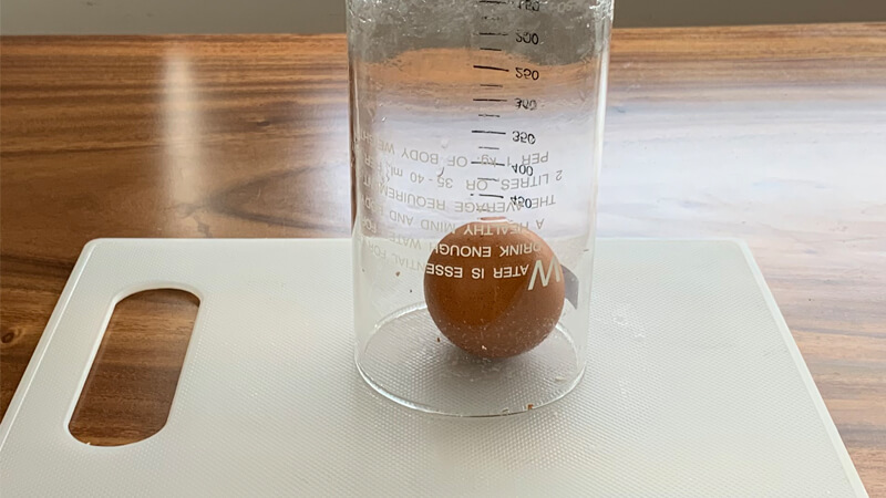 Đặt trứng lên một cái thớt và dùng ly úp vào